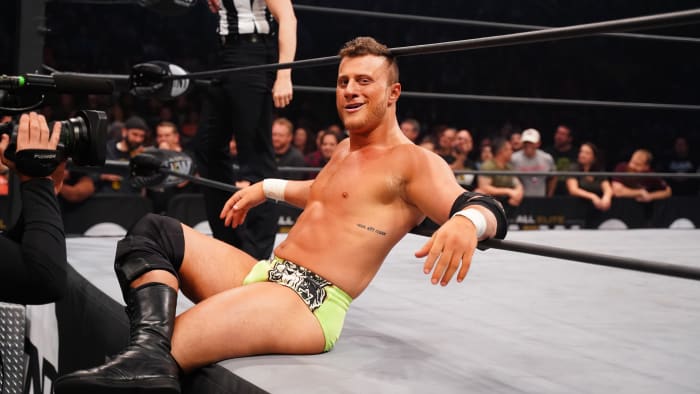 AEW wrestler Maxwell J. Friedman (MJF) smiles wryly while sitting on the ring apron.
